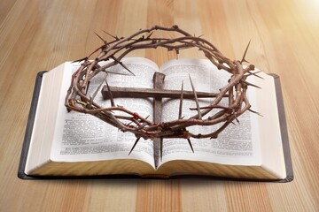 Praying with wooden crucifix cross on Holy Bible study concept