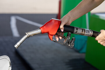 Closeup of woman pumping gasoline fuel in car at gas station. Petrol or gasoline being pumped into...