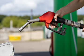 transportation and ownership concept - pumping gasoline fuel in car at gas station
