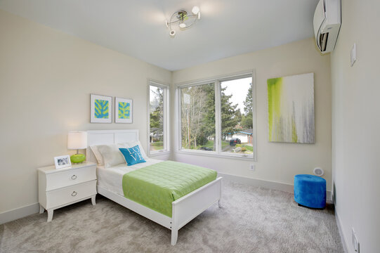 Contemporary blue and green kid's bedroom beige walls and large corner windows. 
