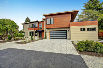 Fototapeta na wymiar Contemporary style home luxury home exterior with brown walls and dark framed metal windows. Green Northwest landscaping. 