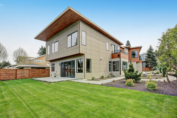 Fototapeta na wymiar Contemporary style home luxury home exterior with brown walls and dark framed metal windows. Green Northwest landscaping. 