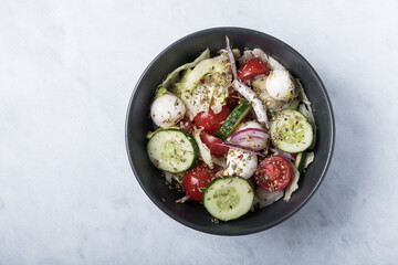 Vegetable salad with mozzarella on a marble table