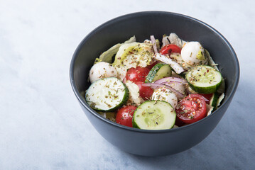 Vegetable salad with mozzarella on a marble table