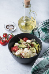 Vegetable salad with mozzarella on a marble table