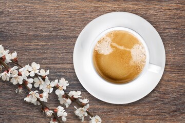 Spring composition with coffee and blooming flowers on the desk