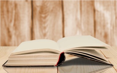 An open old book on a wooden table.