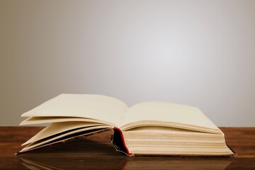 An open old book on a wooden table.