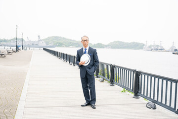 日本人　海を見つめる　スーツ姿の中年男性　