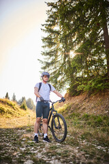 Obraz premium A cyclist rides a bike next to him through the forest roads