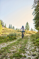 Obraz premium A cyclist rides a bike on extreme and dangerous forest roads. Selective focus