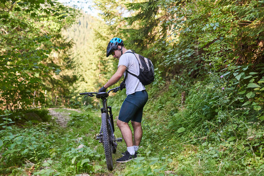 A cyclist rides a bike on extreme and dangerous forest roads. Selective focus