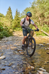 Fototapeta premium A cyclist rides a bike on extreme and dangerous forest roads. Selective focus