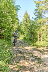 Obraz premium A cyclist rides a bike on extreme and dangerous forest roads. Selective focus