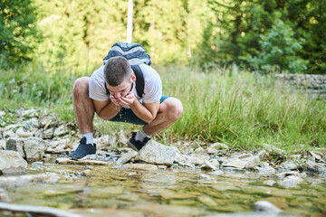 Man drinking fresh spring water while trekking. Selective focus. High-quality photo