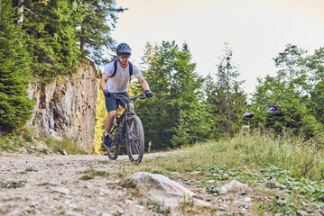 Fototapeta na wymiar A cyclist rides a bike on extreme and dangerous forest roads. Selective focus