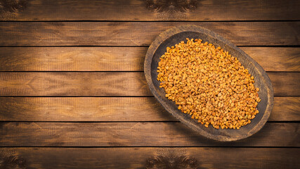 Organic fenugreek seeds in the wooden bowl - Healthy food