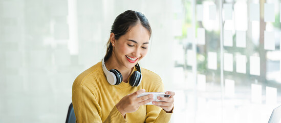 Asian girl student use mobile phone to play game happily