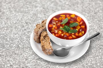 Tasty clear soup with beef slices and vegetables. Served in bowl on desk