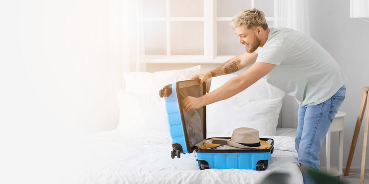Male tourist packing suitcase at home. Banner for design - Powered by Adobe