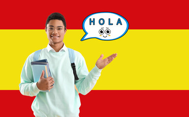 African-American student holding books and speech bubble with word HOLA (HELLO) against flag of Spain © Pixel-Shot