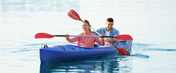 Young couple kayaking in river on summer day