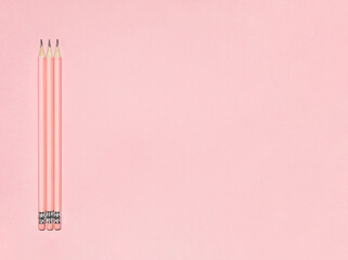 Wooden pastel pink pencils with erasers on pink background. Back to school concept. Monochromatic composition with copy space. Top view, flat lay.