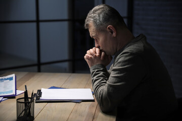 Fototapeta premium Praying mature man in dark room