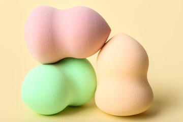Three different makeup sponges on color background, closeup