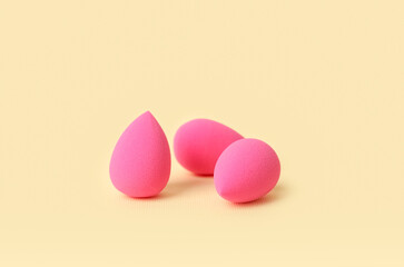 Pink makeup sponges on color background