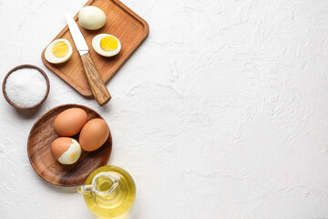 Composition with boiled chicken eggs, salt and oil on light background
