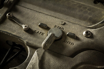 Close-up shot of selective fire of khaki camouflage M4 assault rifle, to be adjusted to fire in...
