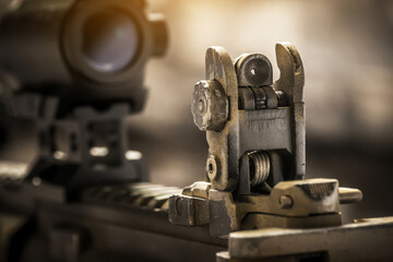 Close-up of flip rear sight and charging handle of assault rifle AR15 khaki camouflage