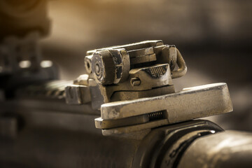 Fototapeta na wymiar Close-up of flip rear sight and charging handle of assault rifle AR15 khaki camouflage