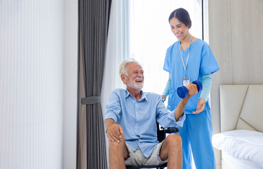 Hospice nurse is helping Caucasian man in wheelchair to exercising muscle strength in pension...