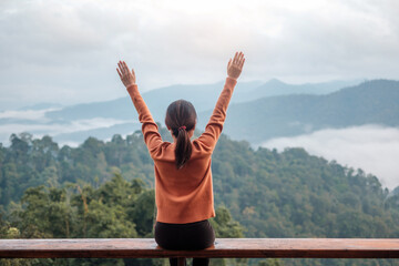 Happy woman relaxing and looking mountain view at countryside home or homestay in the morning. Vacation, blogger, SoloTravel, journey, trip and relaxing concept