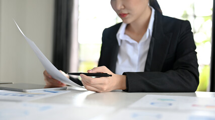 Concentrated female financial business worker analysing the financial report
