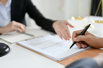 Cropped, A male client signs his signature on the law contract in front of the lawyer