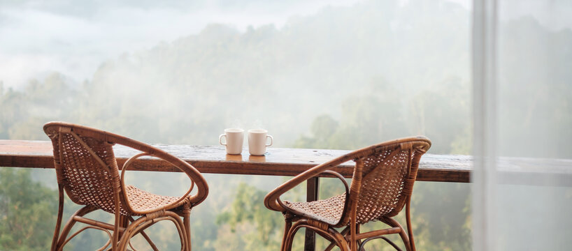 couple White mug of hot coffee or tea on wooden table in the morning with mountain and nature background