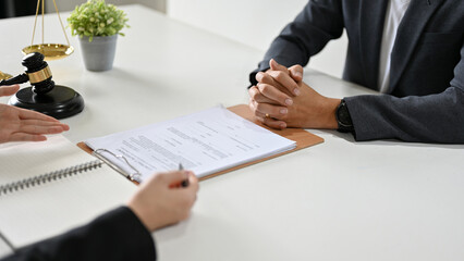 A professional female lawyer counsels and meets with her client to sign a contract agreement.