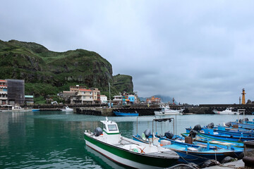 Fototapeta na wymiar Fishing village full of anchored fishing boat in cloudy day