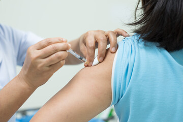 Close up doctor's hand injecting for vaccination in the shoulder woman patient.Vaccine for Covid19...