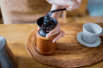 コーヒーミルでコーヒー豆を挽く女性の手