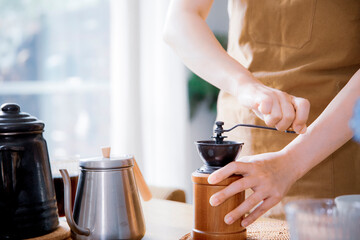 Fototapeta na wymiar コーヒーミルでコーヒー豆を挽く女性の手