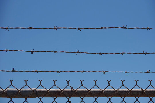 Section of chainlink security fence with barbed wire