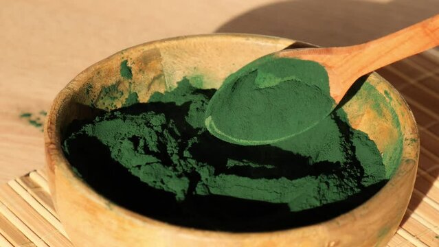 Blue-green algae Chlorella and spirulina powder in bamboo eco bowl, dietary supplement for Vegan, Vegetarian or Plant based diet multivitamins B12, Super powder in spoon. Food supplement source of