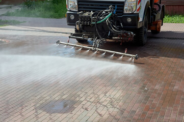 A special machine washes city paths and roads with water