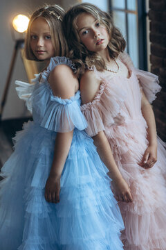 Happy teenage girls in beautiful dresses. Fashion friends, sisters. High quality photo