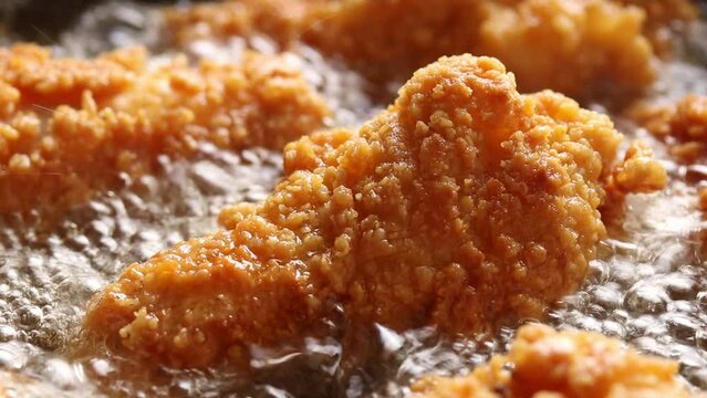 Crispy Chicken Drumsticks are Fried in Boiling Oil. Close up shot