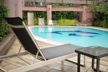 Obraz na płótnie Canvas an empty chair and swimming pool 